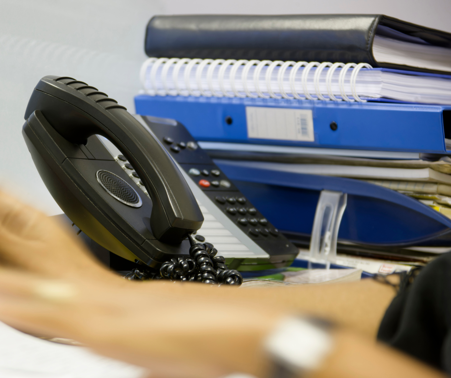 receptionist phone with files piled in the background
